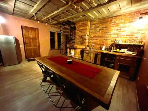Baldone的住宿－Pirts māja Lilijas，厨房配有木桌和砖墙