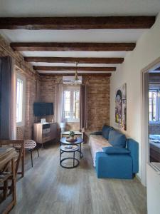 a living room with a blue couch and a table at Casa Collage in Corfu Town