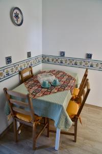 uma mesa de jantar e cadeiras com uma mesa e um prato em casale nonna Elisa relax tra ulivi em San Vito Chietino
