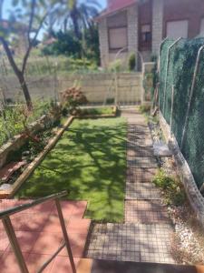a garden with a fence and a yard withgrass at La Casa de Boo in Boó de Piélagos