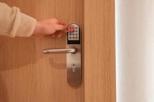 a person unlocking a door with a remote control at Yuna Porte-Maillot - ApartHotel in Paris
