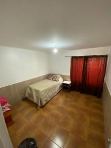 1 dormitorio con cama y cortina roja en Casa Quintero, en Quintero