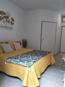 ein Schlafzimmer mit einem großen Bett und einer gelben Decke in der Unterkunft Tikazéla - Escale Tournon-Sur-Rhône in Tournon-sur-Rhône