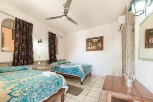 1 dormitorio con 2 camas y ventilador de techo en Hotel San Juan, en Puerto Escondido