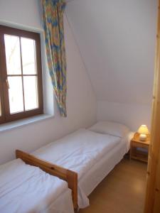 two twin beds in a room with a window at Finnhäuser am Vogelpark - Haus Andrea in Marlow