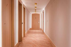 a hallway with a door and a carpeted corridor at Yuna Porte-Maillot - ApartHotel in Paris