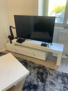a large flat screen tv sitting on a white entertainment center at Appartement Croix rousse 69004 in Lyon