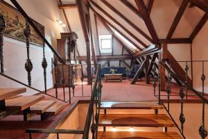 a room with wooden tables and a staircase in a building at Hotel Traube in Mediaş