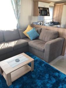 a living room with a couch and a coffee table at Coorie Nook, Chalet 103 in Aviemore