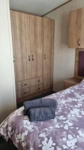 a bedroom with a bed with two towels on it at Coorie Nook, Chalet 103 in Aviemore