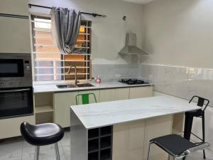 a kitchen with a counter and a sink and a stove at Fowaa Lux in Tema