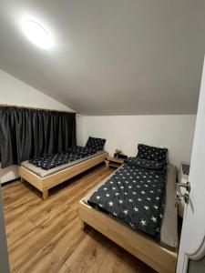 two beds sitting in a room with wooden floors at Cabana Athos in Zalău +24 photos