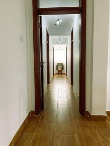 an empty hallway with a long hallway with wooden doors at Riri Country Living Isinya in Kitengela 