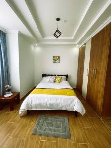 1 dormitorio con 1 cama grande con manta amarilla en Riri Country Living Isinya, en Kitengela 