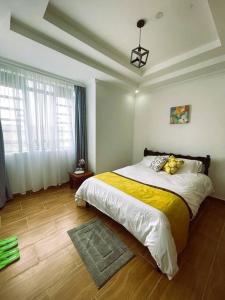 sypialnia z dużym łóżkiem i żółtym kocem w obiekcie Riri Country Living Isinya w mieście Kitengela 