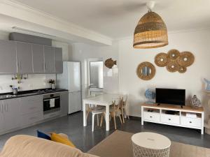 a kitchen and living room with a table and a dining room at Charming villa with private poll in Alcobaça