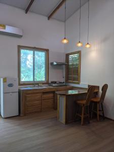 a kitchen with a counter and a sink and a refrigerator at Playa Bluff Lodge in Bocas Town