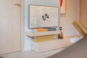 a television sitting on a stand in a room at Yuna Porte-Maillot - ApartHotel in Paris