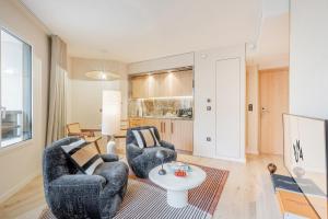 a living room with two chairs and a table at Yuna Porte-Maillot - ApartHotel in Paris