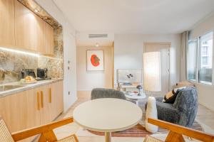 a living room with a table and chairs and a kitchen at Yuna Porte-Maillot - ApartHotel in Paris