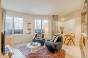 a living room with two chairs and a table at Yuna Porte-Maillot - ApartHotel in Paris