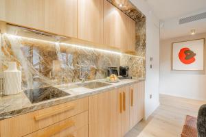 a kitchen with wooden cabinets and a sink at Yuna Porte-Maillot - ApartHotel in Paris