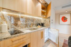 a kitchen with wooden cabinets and a sink at Yuna Porte-Maillot - ApartHotel in Paris