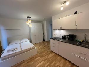 a room with a bed and a kitchen with white cabinets at New Business Apartment Nr.15 in Dresden