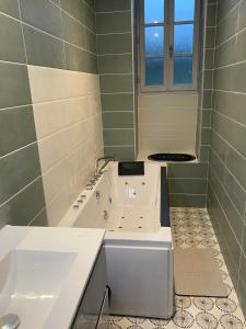 Baño blanco con lavabo y bañera en Au bord du gave, en Laruns