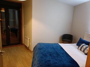 阿瓜爾達的住宿－Malecón Guardes，一间卧室配有一张带蓝色毯子和椅子的床
