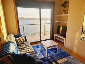 a living room with a couch and a view of the ocean at Malecón Guardes in A Guarda