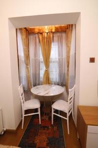 a table and two chairs in a room with a window at Royal Gur Hotel in Istanbul