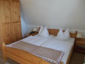 a bedroom with a bed with white sheets and pillows at Finnhäuser am Vogelpark - Haus Luise in Marlow