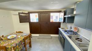 a small kitchen with a table and a stove top oven at Mandorlo Barocco in Noto