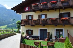 a building with balconies and tables and chairs at Appartements Rienzner in Dobbiaco