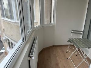 Habitación pequeña con silla y ventana en Mazepa Apartment en Galaţi