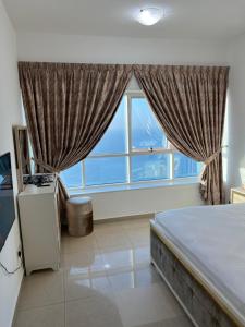 a bedroom with a bed and a large window at Ft 30f R2 SeaView Room at Beach with separate bath in Ajman 