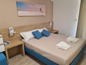 1 dormitorio con 1 cama con almohadas azules y blancas en B&B Al Quadrato, en Scalea
