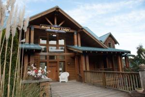 a log cabin with a porch and a sign on it at Moon Water Lodge in Malahat