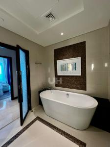 a large white bath tub in a bathroom at Fairmont Marina Residences Apartment in Abu Dhabi