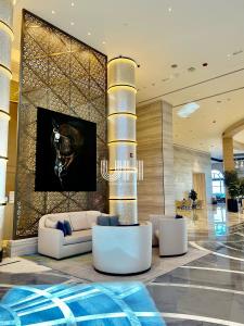 a lobby with a couch and chairs in a building at Fairmont Marina Residences Apartment in Abu Dhabi