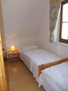 two beds in a small room with a window at Finnhäuser am Vogelpark - Haus Brigitte in Marlow