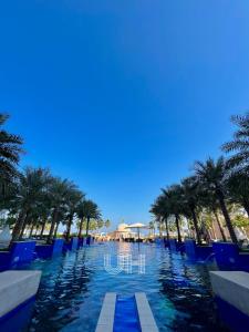 a pool at a resort with palm trees at Fairmont Marina Residences Apartment in Abu Dhabi