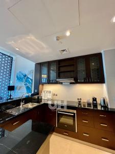 eine Küche mit einer Spüle und einem Herd Top-Backofen in der Unterkunft Fairmont Marina Residences Apartment in Abu Dhabi