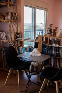 una mesa y sillas en una habitación con libros en Fani's Family House, en Ierápetra