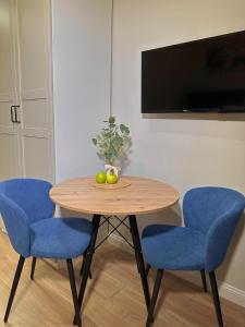 a table with two chairs and a bowl of fruit on it at SKY TOWER APARTMENTS in Warsaw