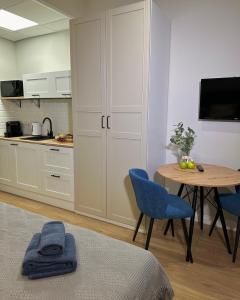 a kitchen with a table and blue chairs in a room at SKY TOWER APARTMENTS in Warsaw