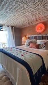 a bedroom with a large bed with flowers on it at Villa Lulu Geribá in Búzios