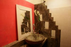 een badkamer met een wastafel en een rode muur bij Galawatta Beach Resort in Unawatuna
