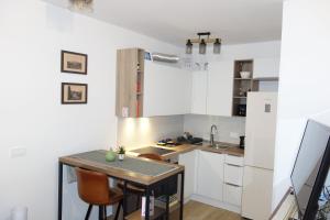 a kitchen with white cabinets and a table and chairs at City Centre Samobor in Samobor